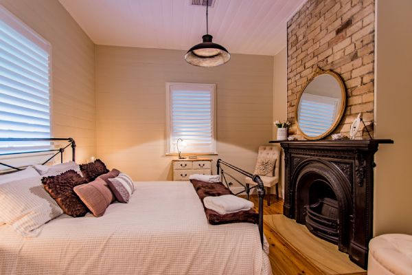 Master bedroom with queen bed and original fireplace