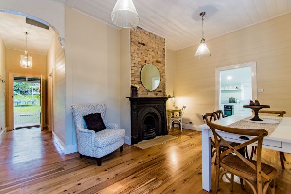 Living and dining area with original sandstock brick fireplace